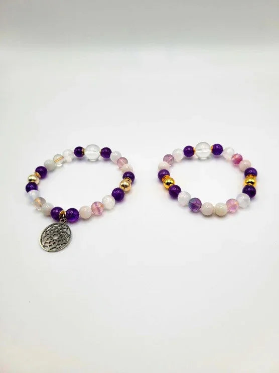 Pair of gemstone beaded spiritual bracelets with purple, white, gold accents and charm pendant