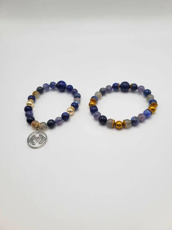 Pair of gemstone beaded bracelets with gold accents, one featuring a round silver charm.