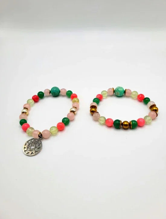 Colorful beaded spiritual bracelets with gold accent beads and pendant on white background