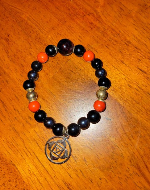 Black tourmaline, obsidian, garnet, and sterling silver grounding crystal bracelet for root chakra healing, featuring a stylish beaded design.