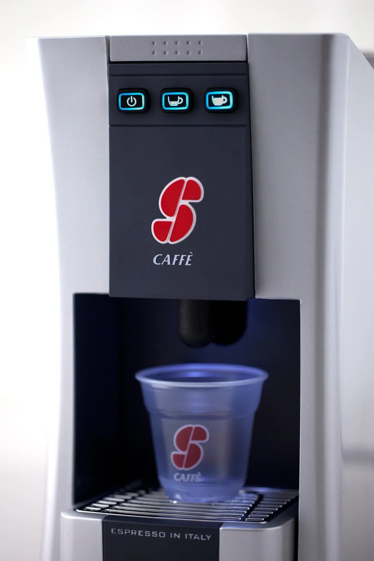 Italian espresso coffee machine with branded plastic cup in dispenser
