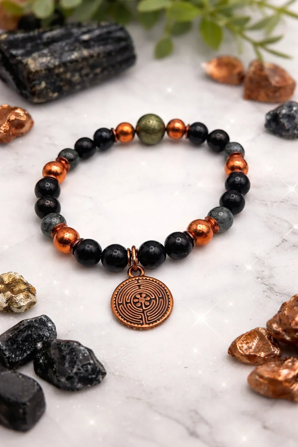 Spiritual beaded bracelet with metallic charm on marble, wellness and gemstone energies