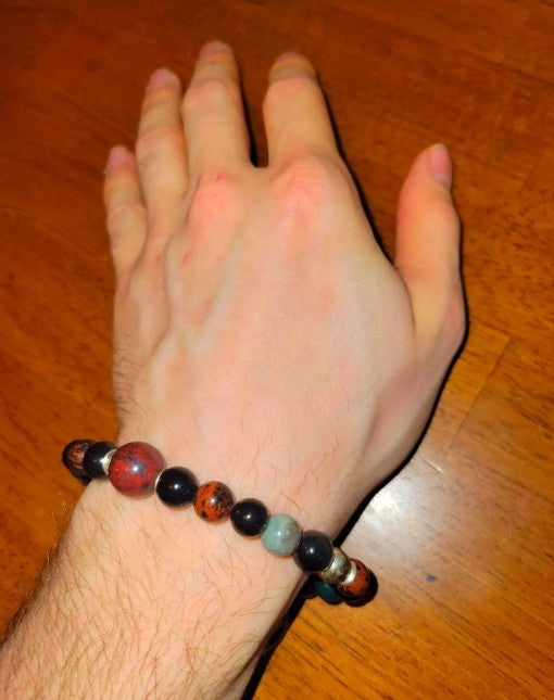 Root chakra grounding bracelet with rainbow obsidian, blood stone, and jet beads, featuring healing energy jewelry for women.
