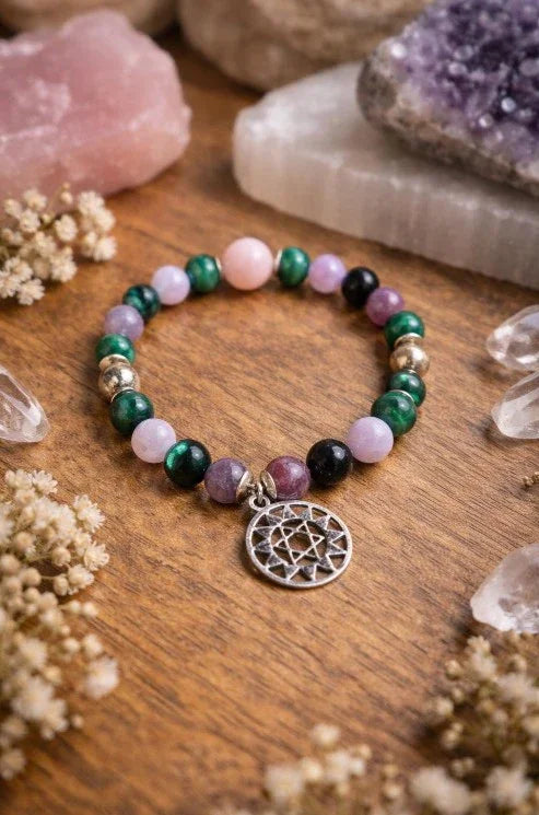 Crystal beaded spiritual bracelet with silver geometric charm on wood, surrounded by gemstones