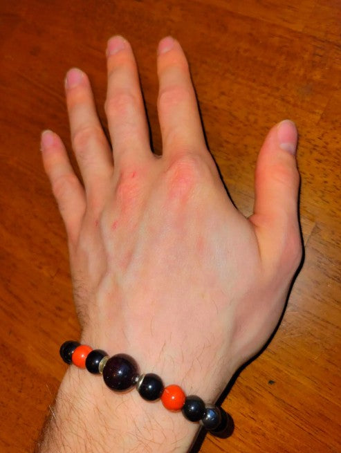 Black tourmaline, obsidian, garnet, and sterling silver grounding crystal bracelet for root chakra healing, featuring natural stone beads.