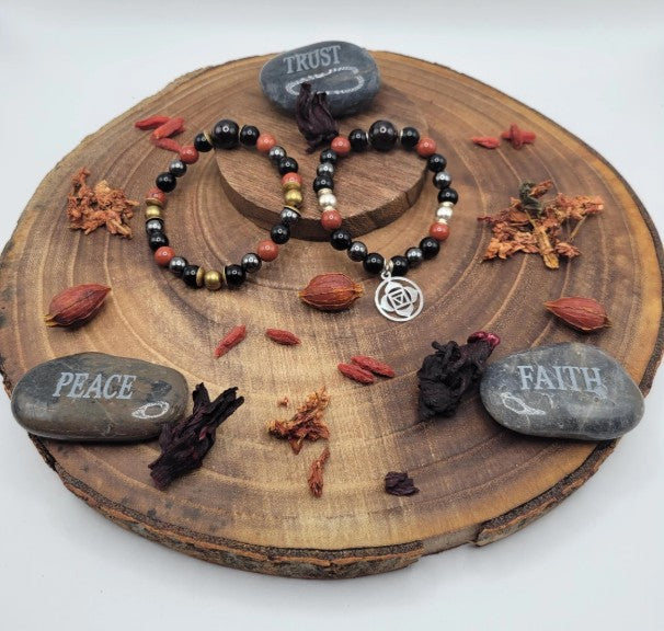 Black Tourmaline, Obsidian, Garnet, and sterling silver grounding crystals on a Root Chakra healing bracelet.