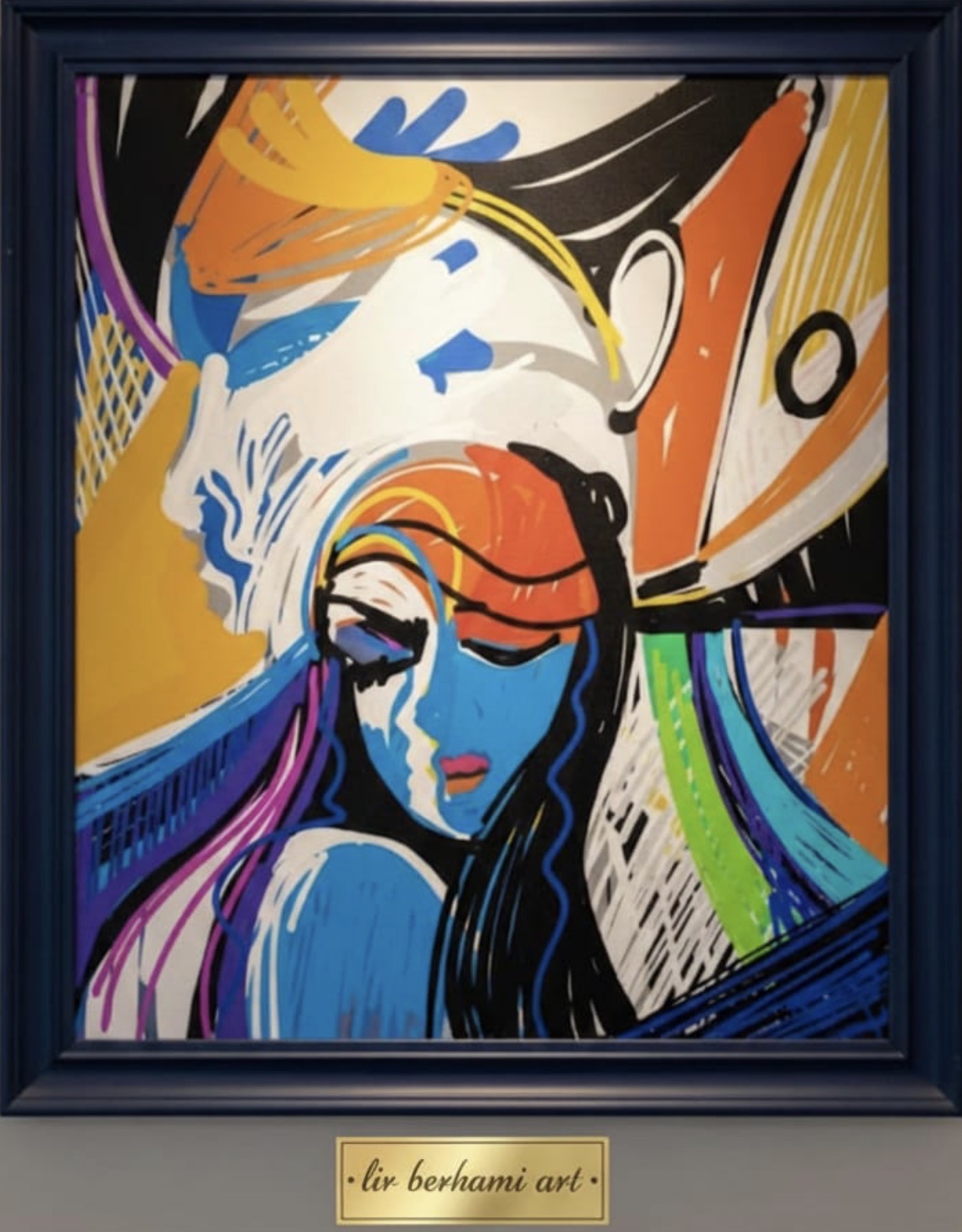 Colorful abstract wall art featuring a woman with bold lines and vibrant hues in a blue frame.